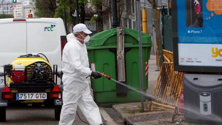 Un empleado de la limpieza desinfecta una zona de contenedores en Vigo.