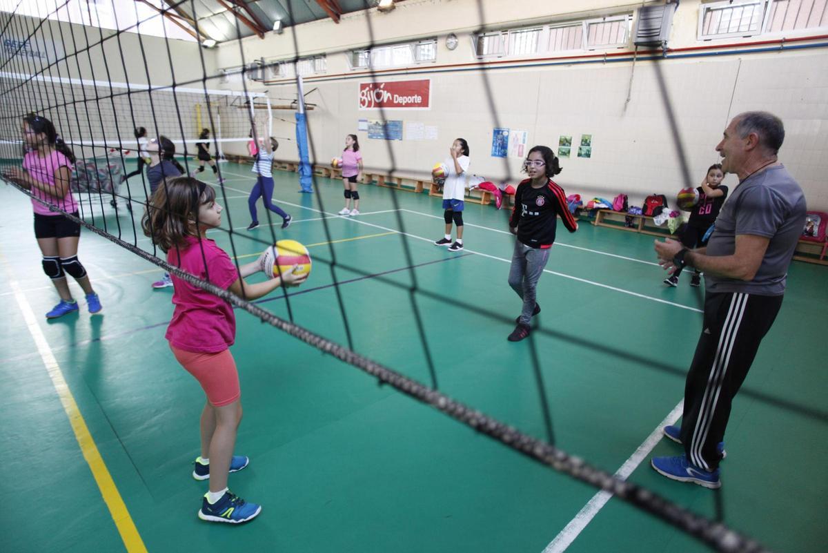 Escolares practicando en una pista de voleibol.