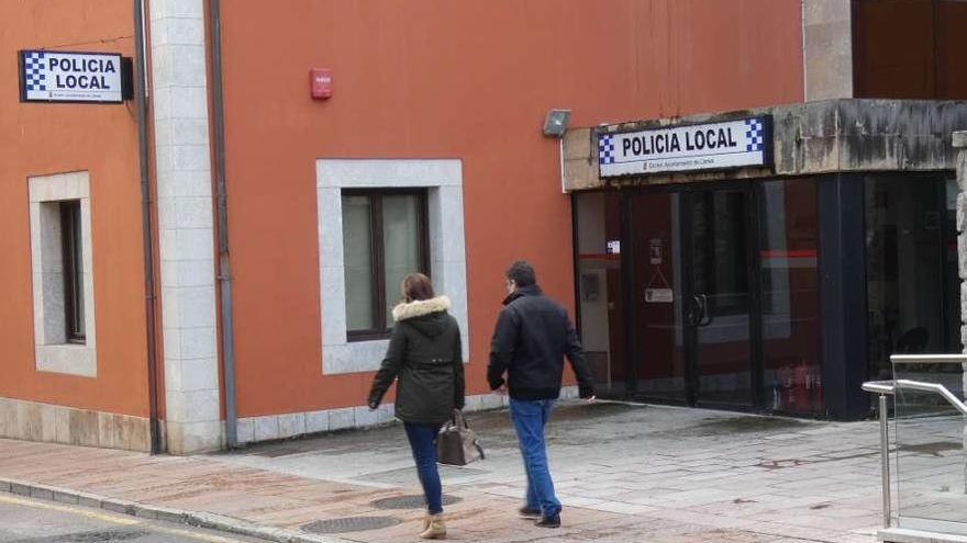 Dos vecinos pasando ayer por la tarde delante de las oficinas de la Policía Local de Llanes.