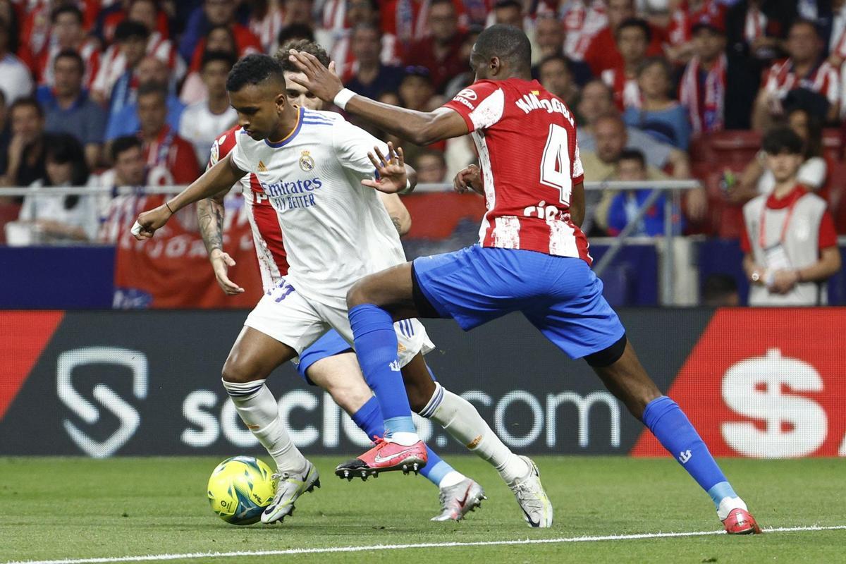 MADRID, 08/05/2022.- El delantero brasileño del Real Madrid, Rodrygo (i), intenta llevarse el balón ante el centrocampista francés del Atlético de Madrid, Geoffrey Kondogbia, durante el encuentro correspondiente a la jornada 35 que disputan hoy Domingo en el estadio Wanda Metropolitano, en Madrid. EFE / Rodrigo Jiménez.