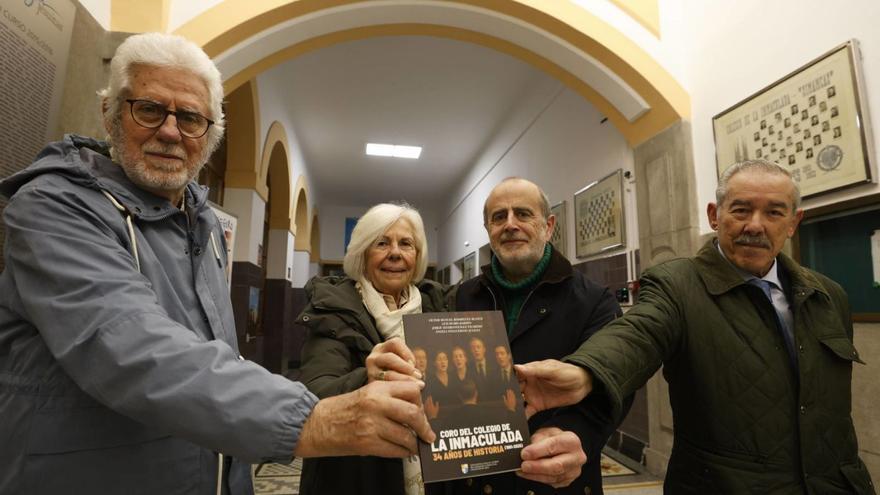 Por la izquierda, Luis Rubio, Luisa Peláez, Víctor Rodríguez y Jorge Alvargonzález, en el colegio de la Inmaculada, con el libro en el que recopilaron la historia del coro de padres del centro de los Jesuitas. | LUISMA MURIAS