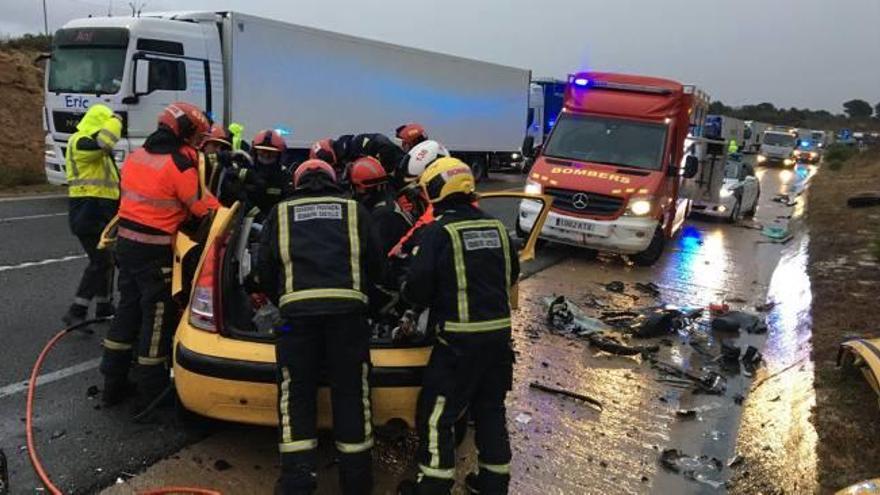 Los bomberos excarcelan a los atrapados de uno de los coches tras el choque.