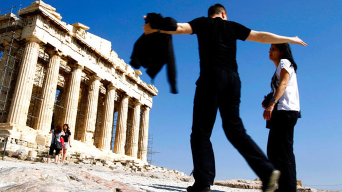 Una parella de turistes visiten el Partenó en un moment en què el Govern grec calcula una reducció de 9% en l’afluència de turistes a causa de la crisi que viu el país.