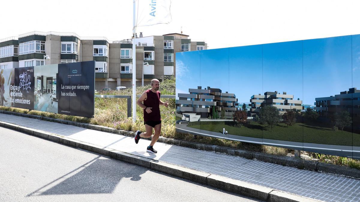 Un corredor pasa ante el anuncio de una promoción de viviendas del Rinconín, en Gijón