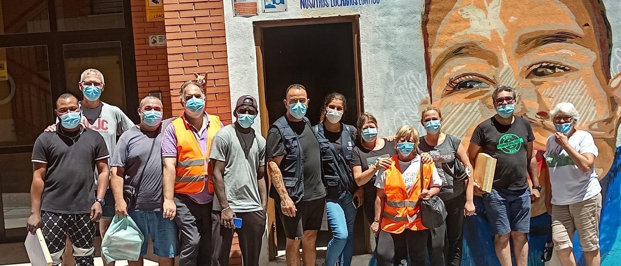 El presidente vecinal Curro López, en el centro, con un grupo de voluntarios de la asociación durante las restricciones de la pandemia. Detrás, un mural de ánimo a Ayoub.