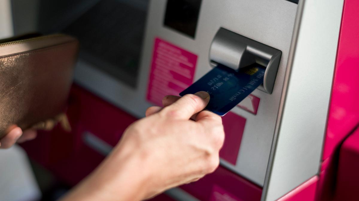 Una persona sacando dinero del cajero