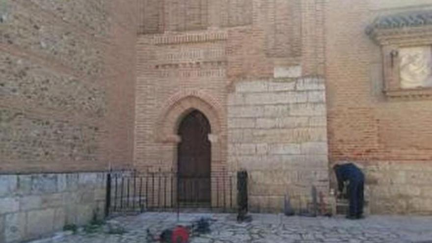 Un operario instala una verja en el Santo Sepulcro para evitar que vecinos orinen junto al templo.