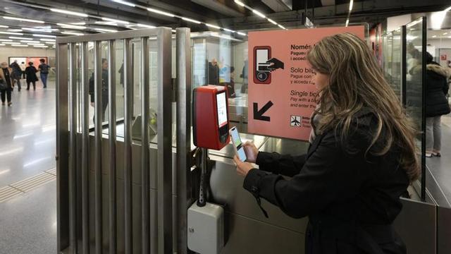 Una usuària a l’estació de metro de Sagrada Família accedeix a través del pagament amb targeta bancària.  | FERRAN NADEU
