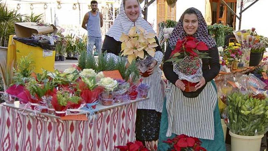 Vendedoras de flores muestran el artículo estelar de la feria, las poinsetias de colores.