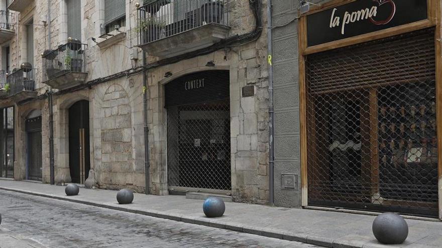 Diversos establiments comercials amb la persiana abaixada, al barri vell de Girona