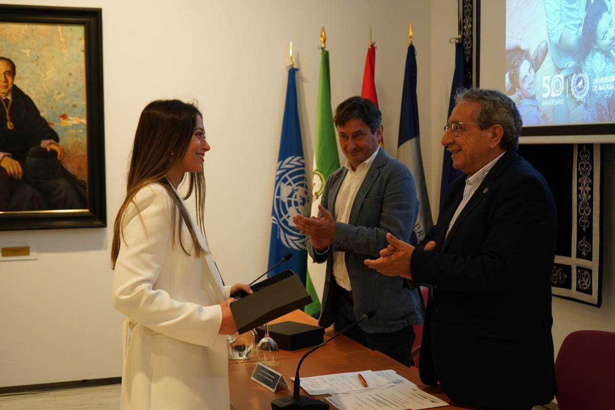 Inmaculada Silvana Seldaño recogiendo su reconocimiento de manos del rector de la UMA