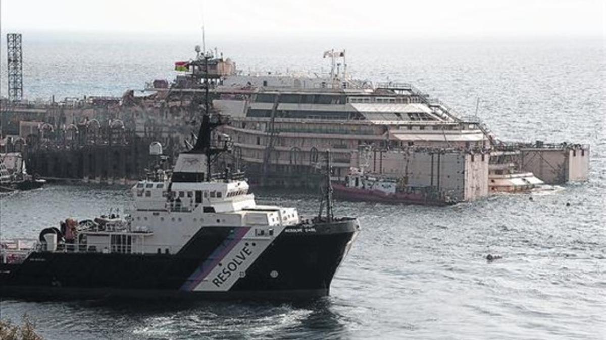 En equilibrio 8El 'Costa Concordia', en segundo plano, sostenido por diques neumáticos.