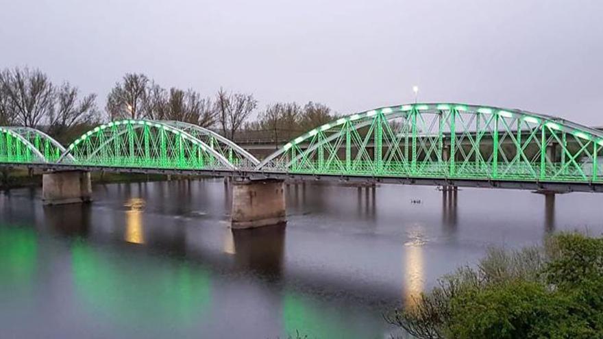 El puente de Coria, iluminado de verde hasta que se levante el estado de alarma