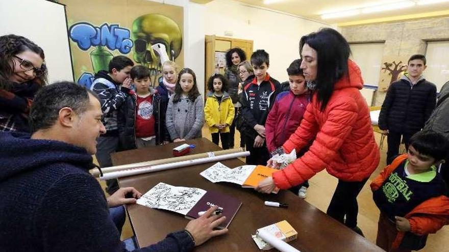 Luis Davila, ayer, con varios niños en la biblioteca. // A. Hernández