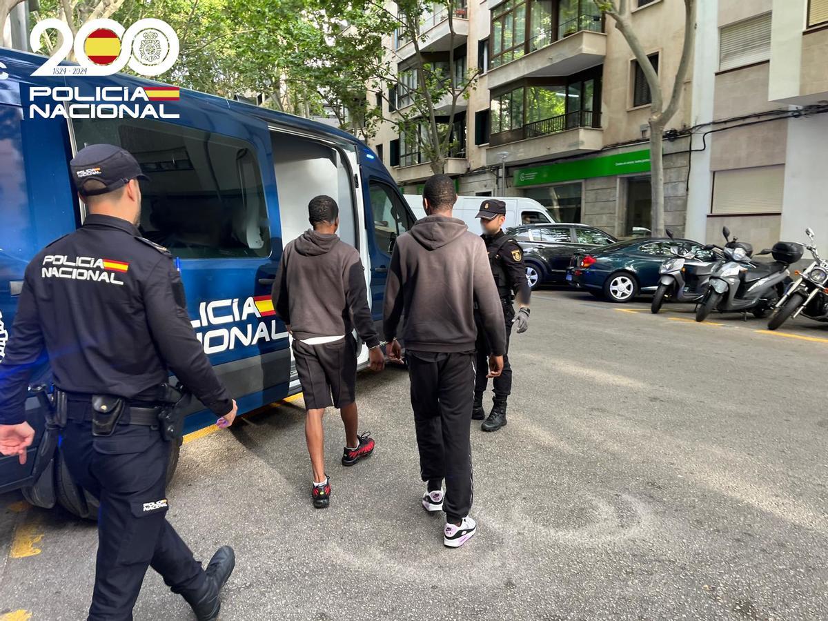 Agentes de la Policía llevan detenidos a los dos presuntos atracadores.