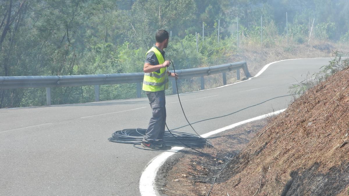 Un operario repone la conexión de fibra óptica entre la carretera de Castrelo y Cartelle.