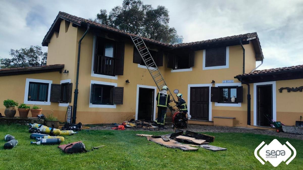 Los bomberos trabajan en la vivienda donde se originó el incendio.