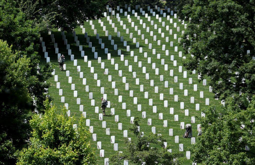 Soldados del 3º Regimiento de Infantería ponen banderas frente a las tumbas del Cementerio Nacional de Arlington, en Washington (EE UU)