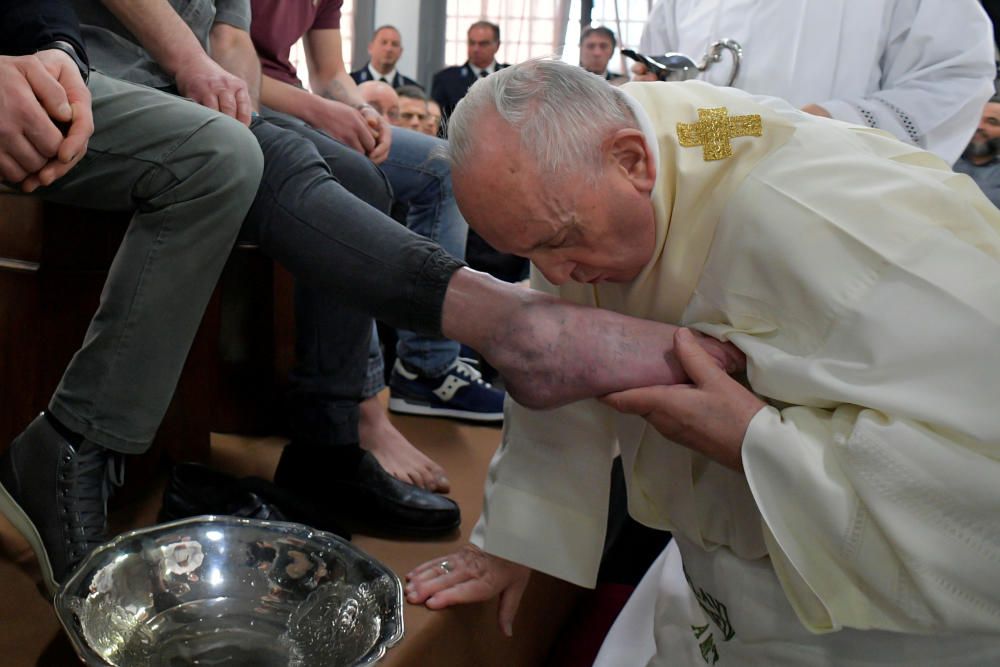 Pope Francis kisses a foot of an inmate during ...
