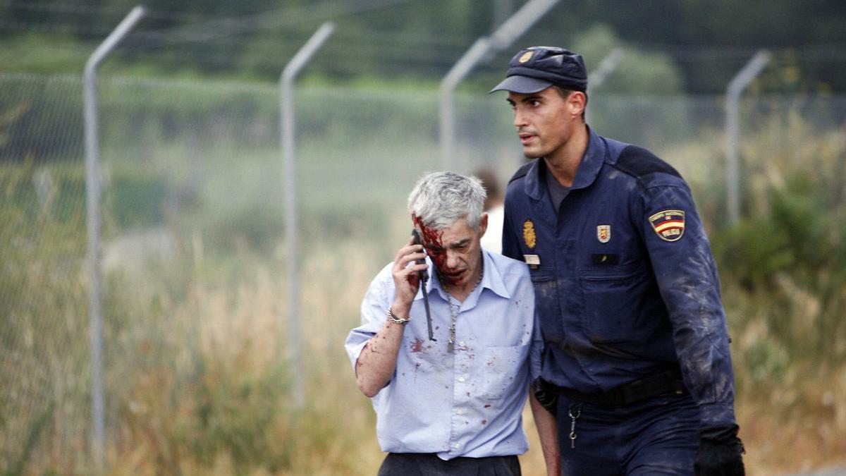 El maquinista del Alvia, malherido y asistido por un policía el día del trágico descarrilamiento en la curva de Angrois.