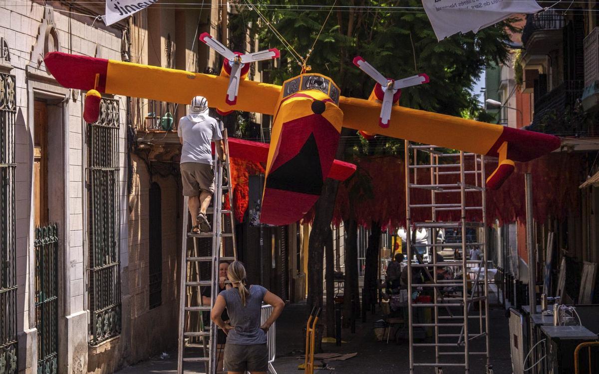 Treballs de decoració del carrer Joan Blanques de Baix, dedicada als avions antiincendis. | EL PERIÓDICO