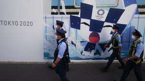 Policías japoneses pasan frente a un cartel que anuncia los Juegos Olímpicos de Tokio 2020 en la ciudad nipona de Hiroshima.