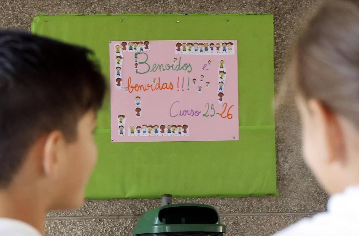Un par de estudiantes contempla un cartel de bienvenida en la vuelta al cole este curso.