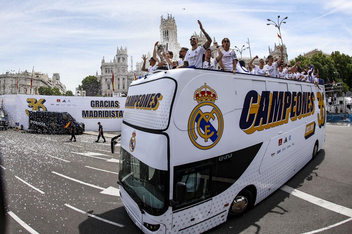 Los jugadores del Real Madrid saludan desde el autobús a los aficionados en la Plaza de Cibeles