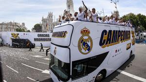 Los jugadores del Real Madrid saludan desde el autobús a los aficionados en la Plaza de Cibeles
