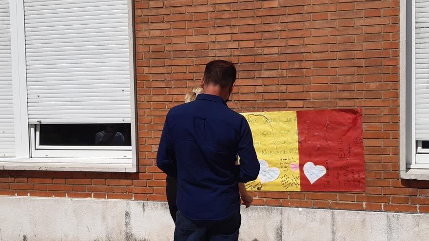 Familiares del joven agredido en Amorebieta ante el cartel de apoyo que se ha colocado en la fachada del hospital de Cruces, donde permanece ingresado.