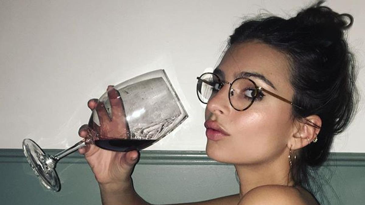 Emily Ratajkowski tomando una copa de vino en la bañera