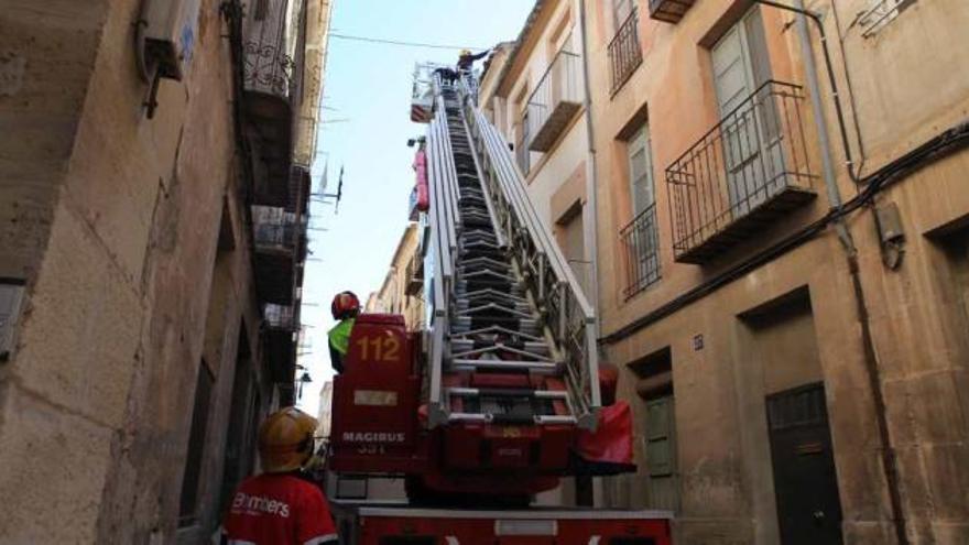 Los bomberos accedieron hasta los tejados con la escalera y eliminaron las tejas que estaban a punto de caer.