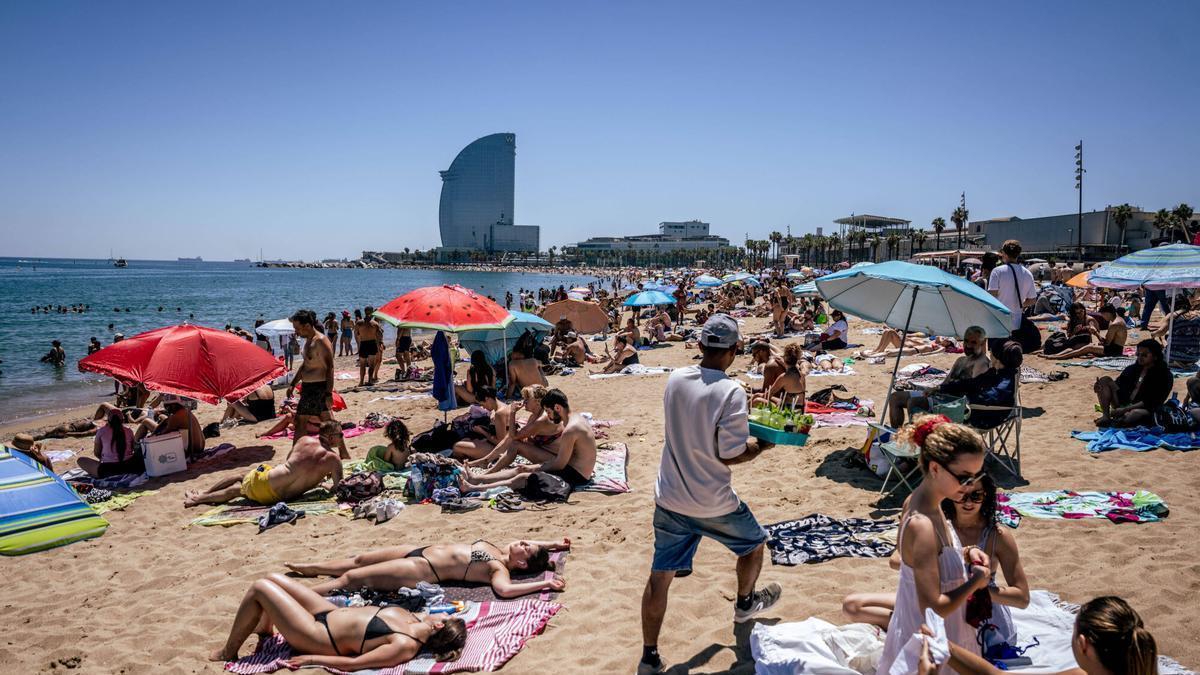 El calor llena las playas de Barcelona. En la imagen, bañistas este sábado.
