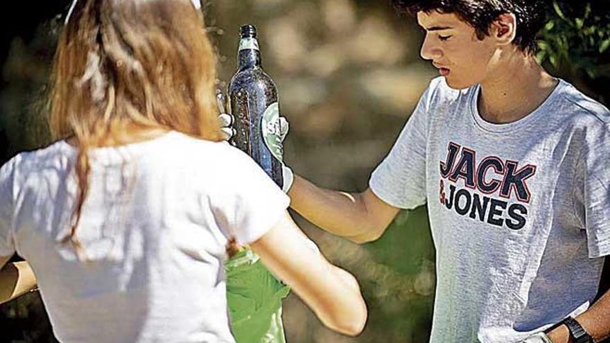 Un joven deposita una botella en una bolsa.