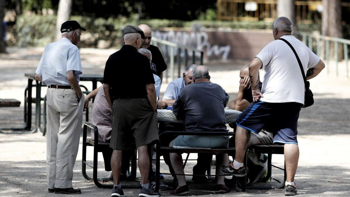 Varios pensionistas juegan al dominó en un parque. |  Eduardo Parra