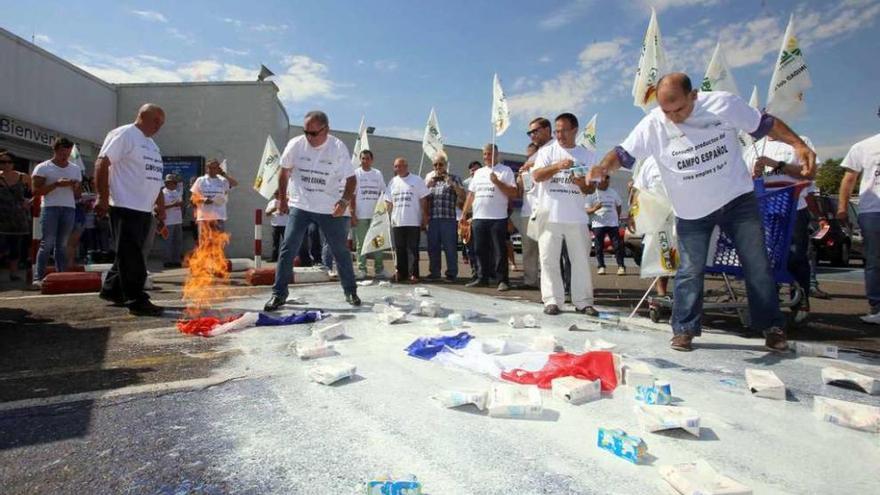 Ganaderos arrojan leche francesa frente al supermercado Carrefour.