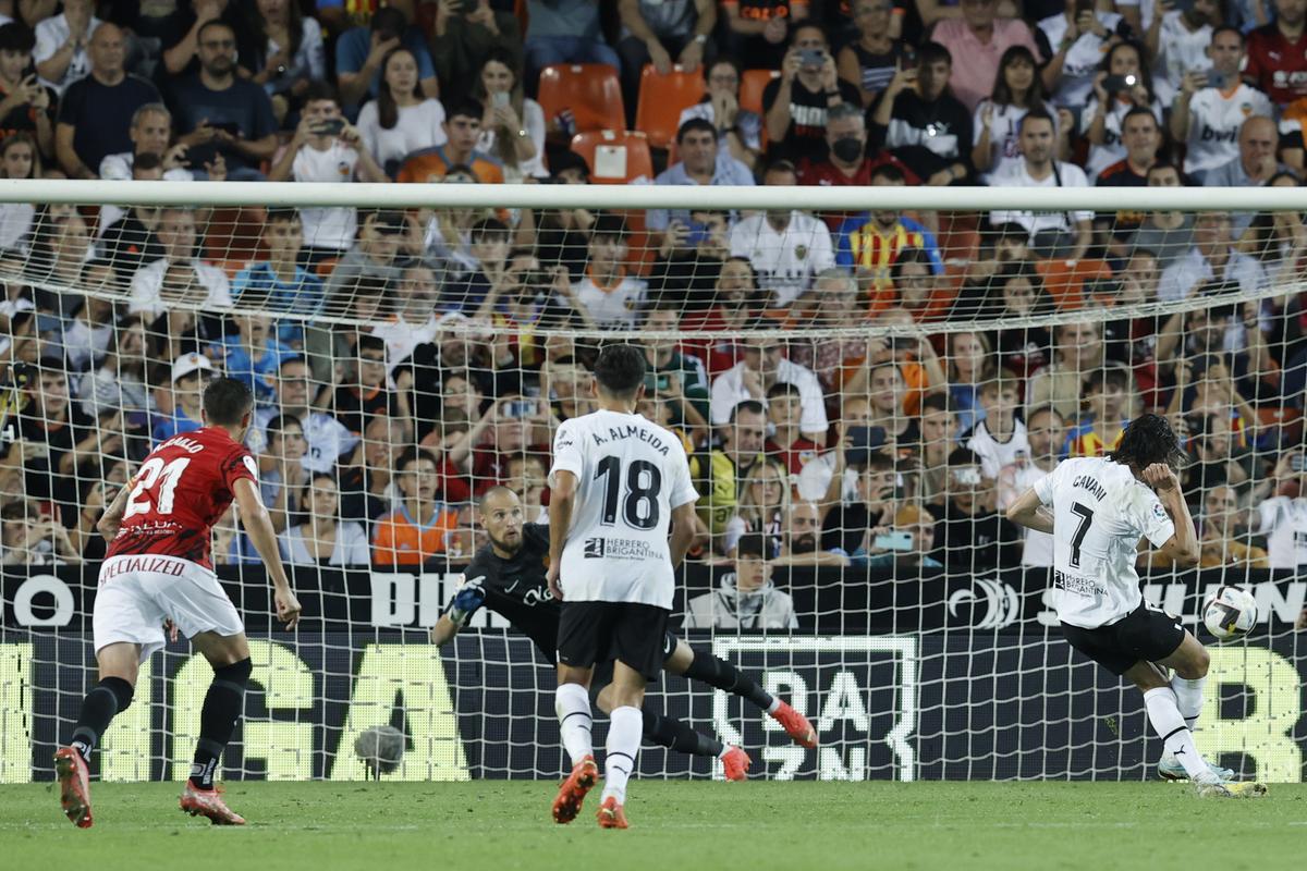 El delantero uruguayo del Valencia, Edinson Cavani (d), golpea el balón desde el punto de penalti ante el guardameta serbio del Mallorca, Predag Rajkovic, para conseguir el primer gol del equipo valencianista durante el encuentro correspondiente a la jornada 11 de primera división disputado en el estadio de Mestalla, en Valencia. EFE / Kai Forsterling.
