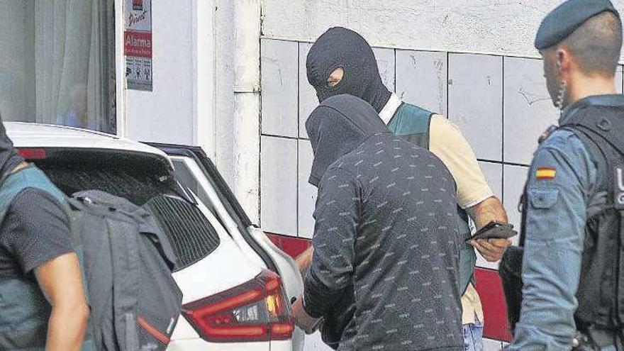 Un detenido en Cambados, ayer, junto a guardias civiles. // I. Abella