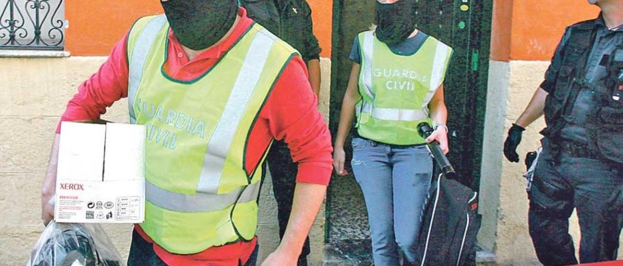 Agentes de la Guardia Civil salen de una de las viviendas registradas en la operación de 2007.