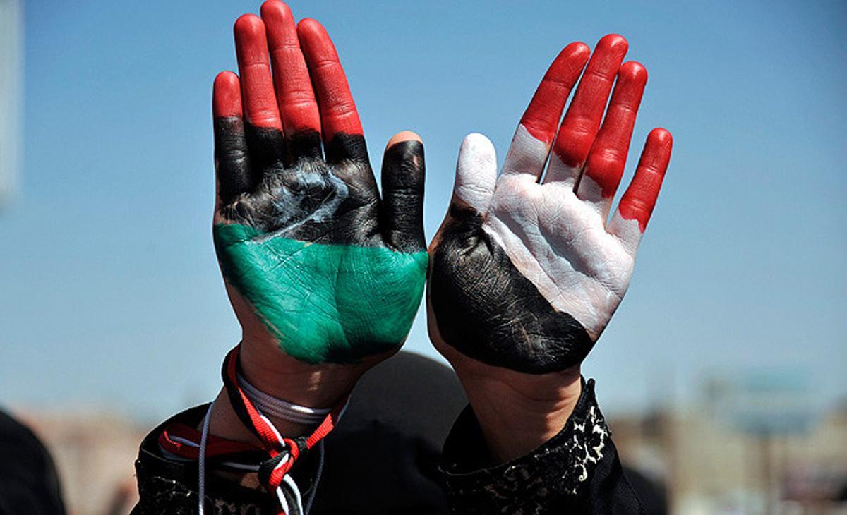 Una opositora mostra les seves mans amb els colors de la bandera de Líbia (esquerra) i la del Iemen (dreta) en una manifestació contra el president iemenita, Ali Abdul·là Salih a Sanà, Iemen.