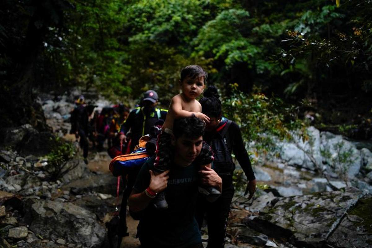 Migrantes cruzan el río Muerto en el Tapón del Darién, de viaje hacia los Estados Unidos, en Acandi, Colombia