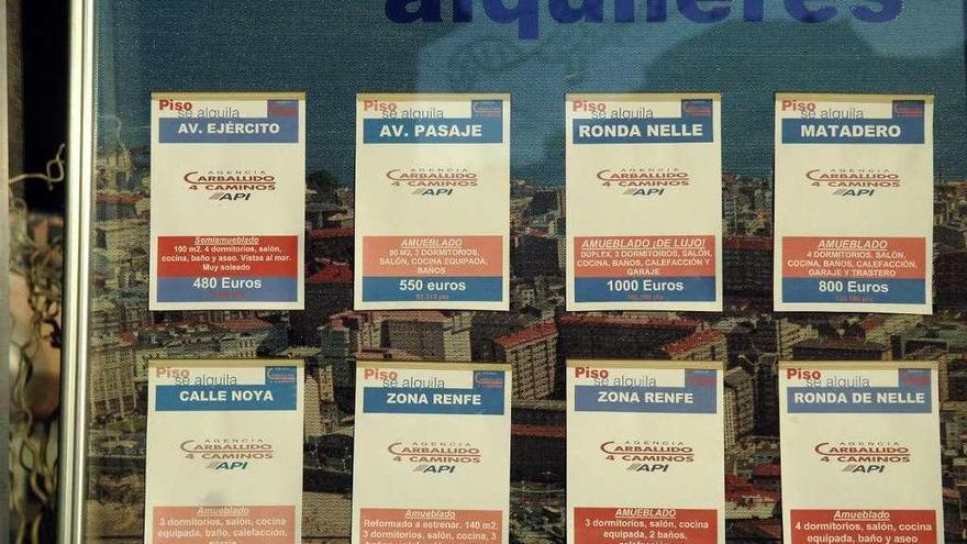 Carteles con ofertas de pisos en alquiler en una inmobiliaria de A Coruña.