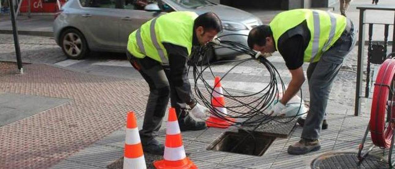 Operarios reponiendo la fibra óptica, ayer, en la calle Ildefonso Sánchez del Río de la Pola.