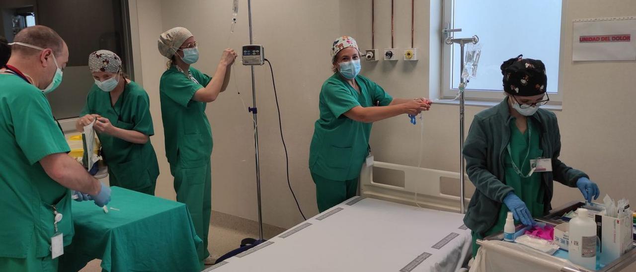 Varias trabajadoras del servicio de UCSI del hospital de Gandia preparan una cama. | LEVANTE-EMV