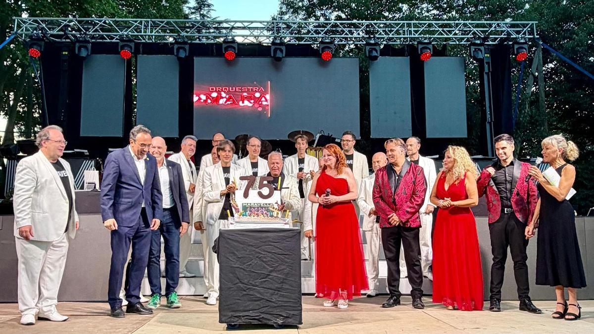 Membres de l'Orquestra Maravella bufant les espelmes acompanyats de les autoritats