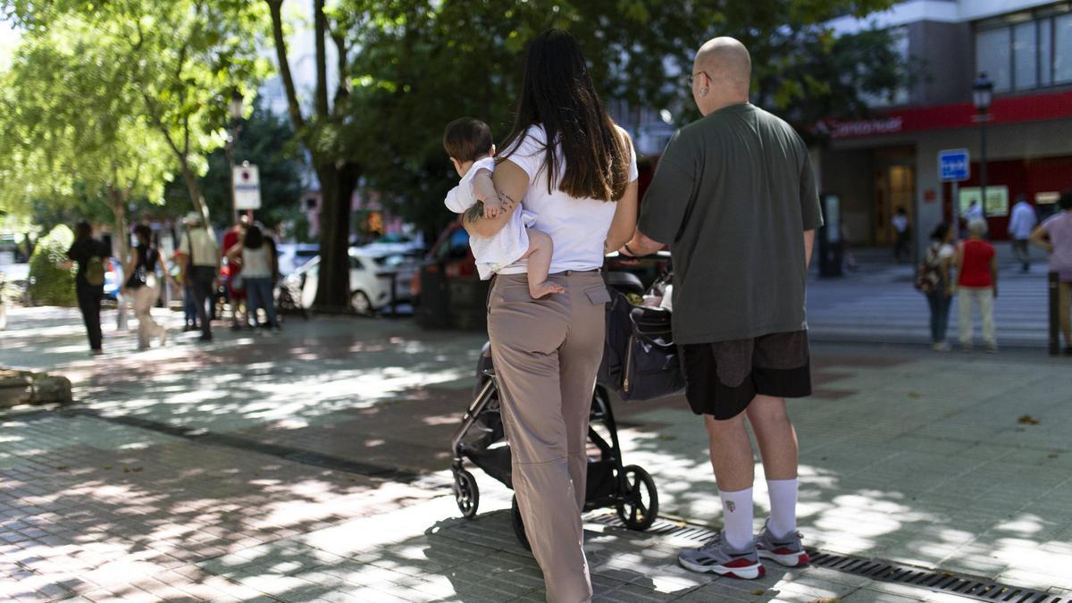 Una familia pasea por Cánovas con su bebé.