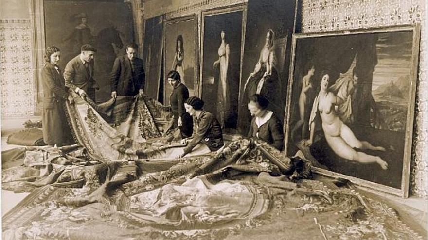 Reparación de tapices en el depósito del Colegio del Patriarca en una imagen tomada por José Lino Vaamonde para la Exposición Internacional de París.