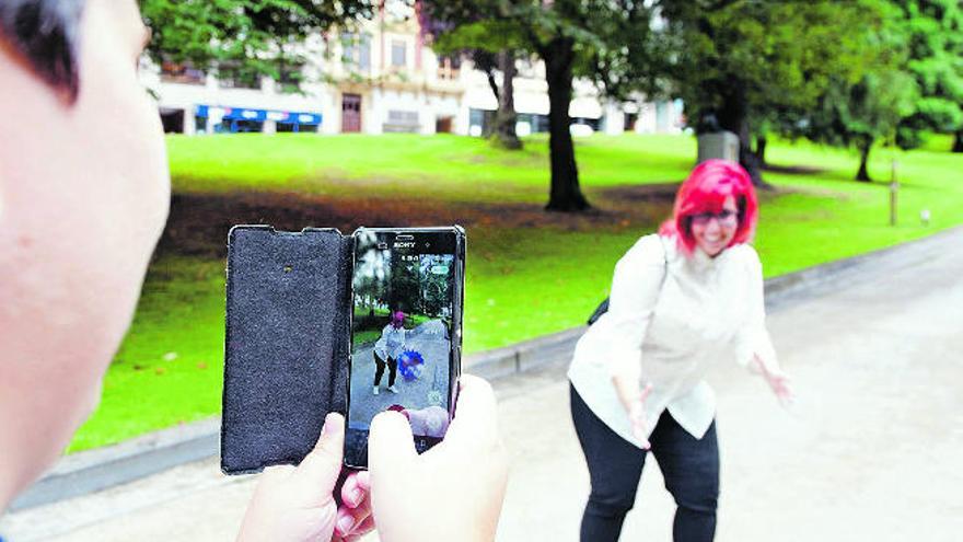 Un jugador hace una fotografía a su compañera para que aparezca en el teléfono móvil con un pokémon.