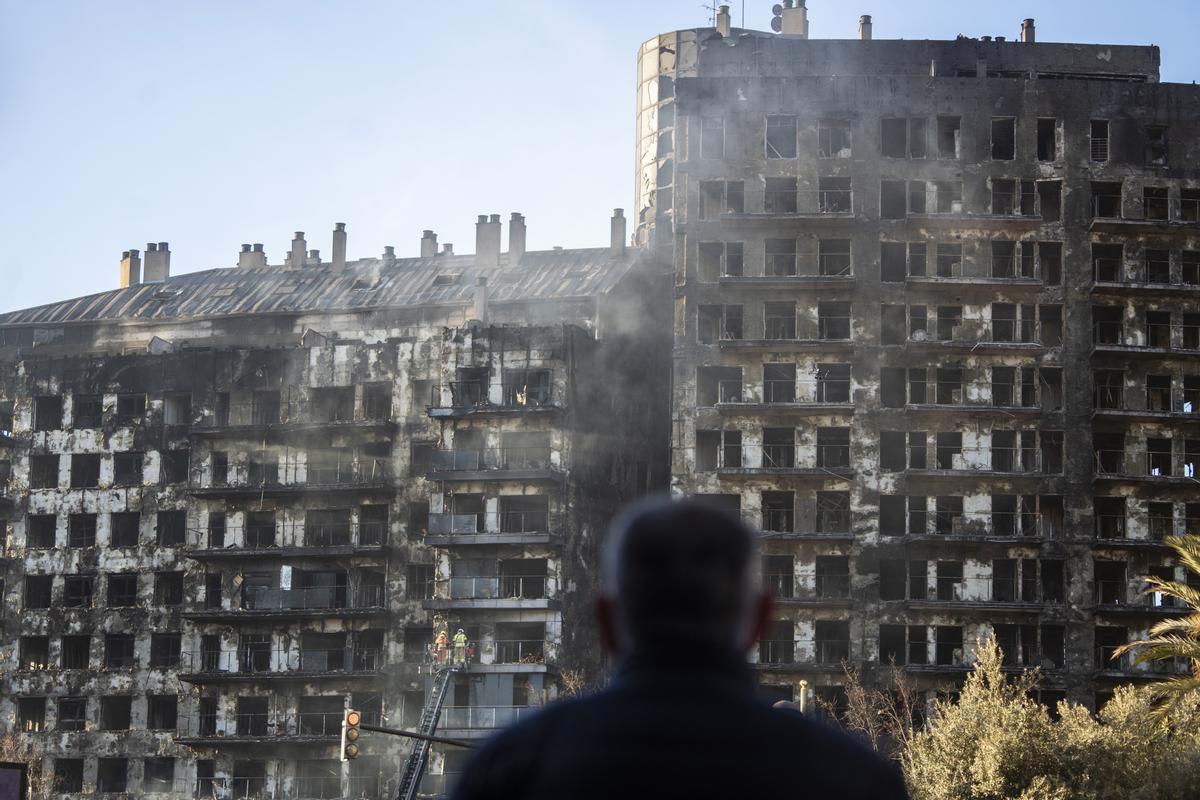 Un hombre observa la estructura del edificio tras el incendio de ayer, 22 de febrero, en el barrio de Campanar, a 23 de febrero de 2024, en Valencia, Comunidad Valenciana (España). Un incendio de grandes dimensiones arrasó ayer un edificio de 14 plantas e