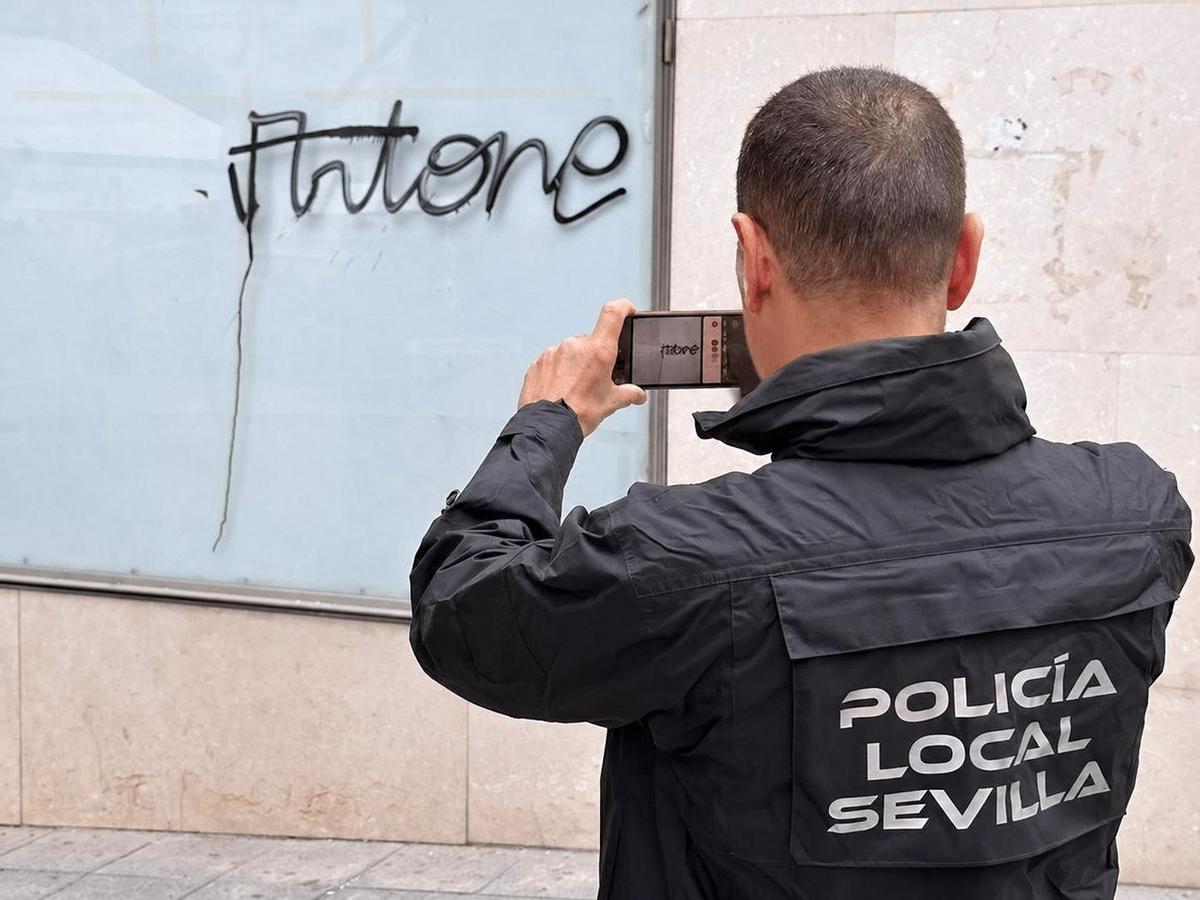 Un agente de la Policía Local toma una fotografía de una de las pintadas de Artone
